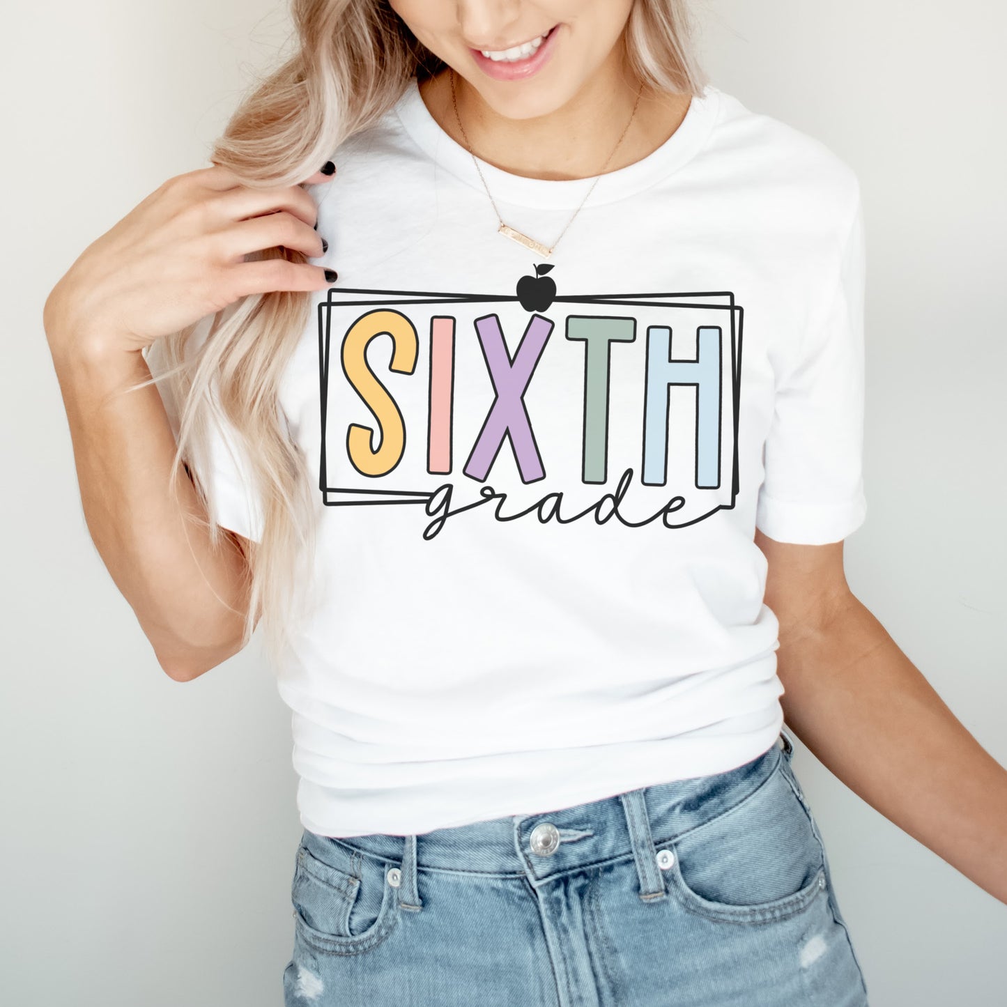 sixth grade teacher shirt multicolored vibrant font with black rectangle borders and apple white color